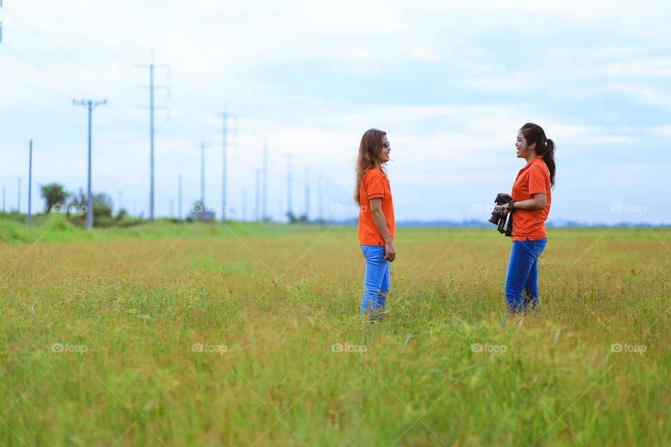 Two friend are talking . After one of a friend taking photo for her friend, both of them relaxing and enjoy with the view.