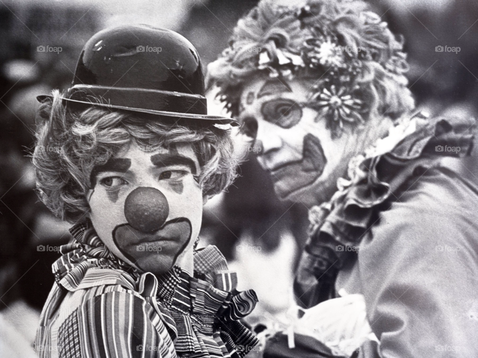 sad clowns watch as their team loses during football game. by arizphotog