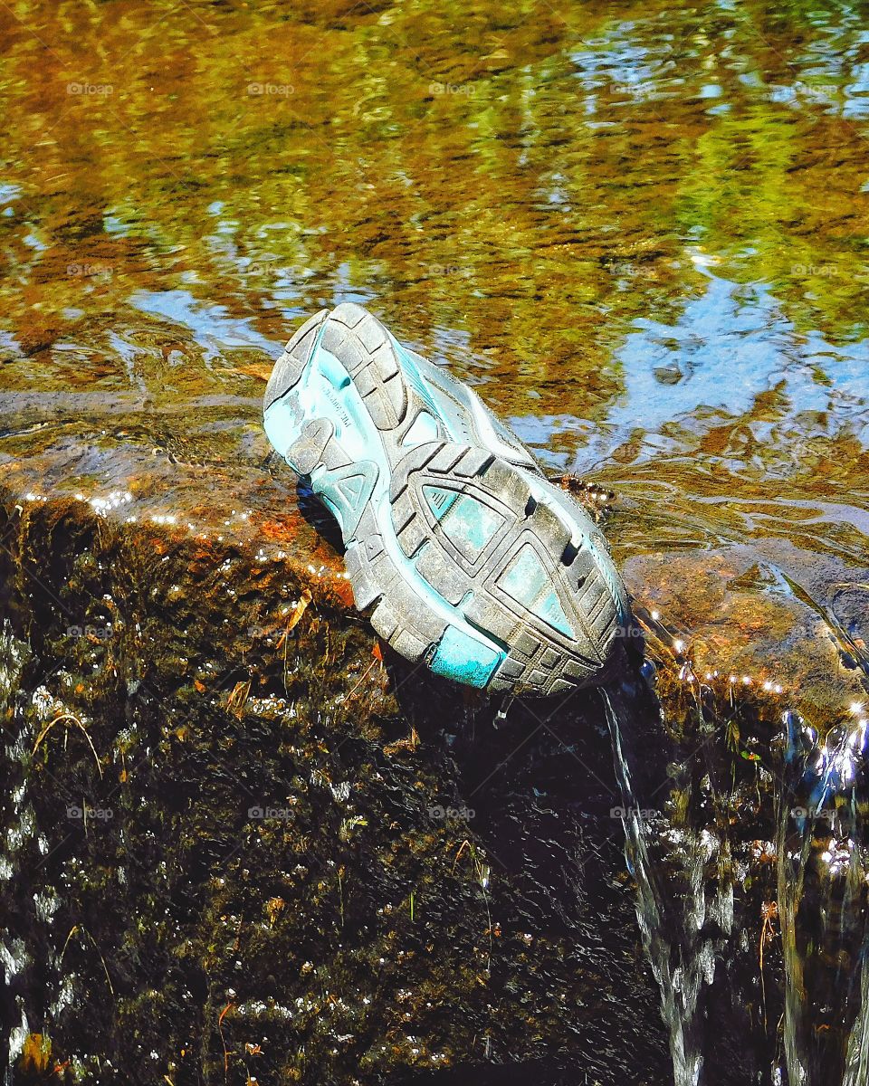 Someone lost a Nike sneaker on a waterfall 