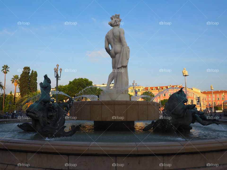 Sun fountain with statue of Apollo and mythological bronze figures on the Place Massena in Nice, France.
