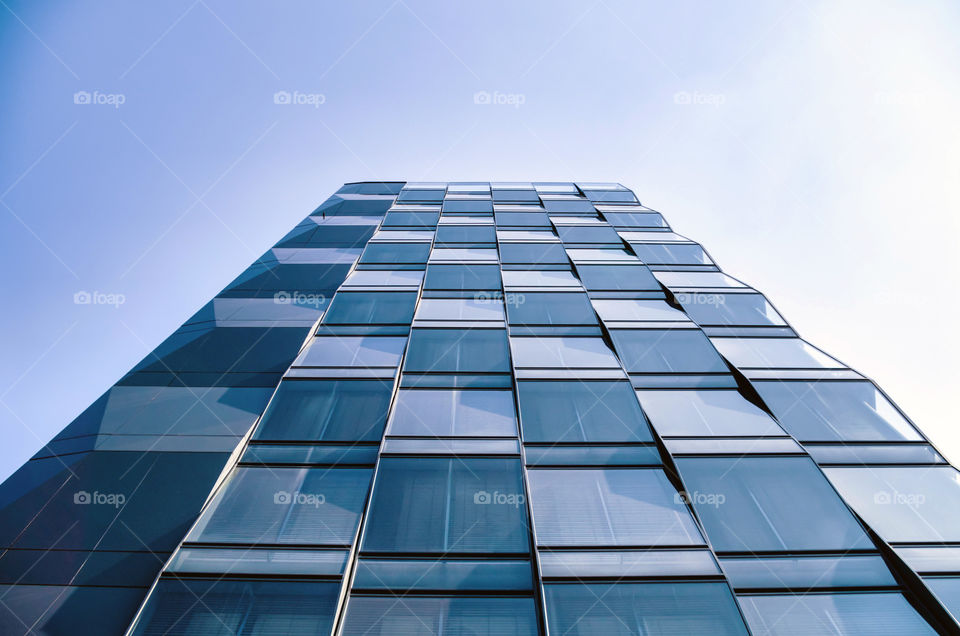 Low angle view of modern building against blue sky.
