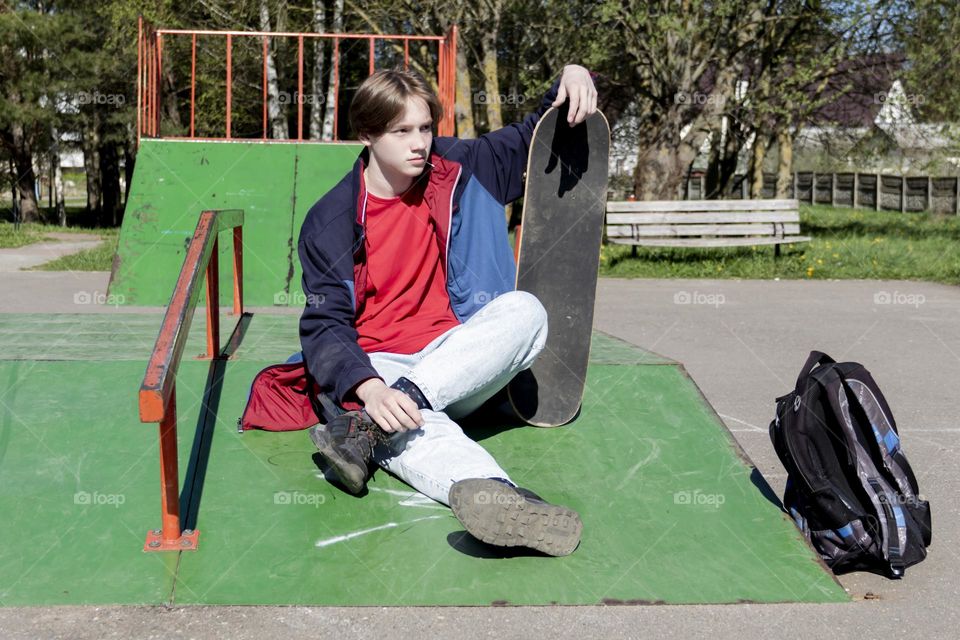 Hobbyist teenager goes in for sports, has fun and rides a skateboard in the park outdoors.