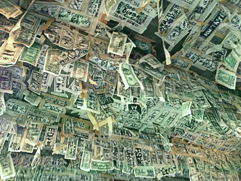 A ceiling of signed dollar bills at an island restaurant.