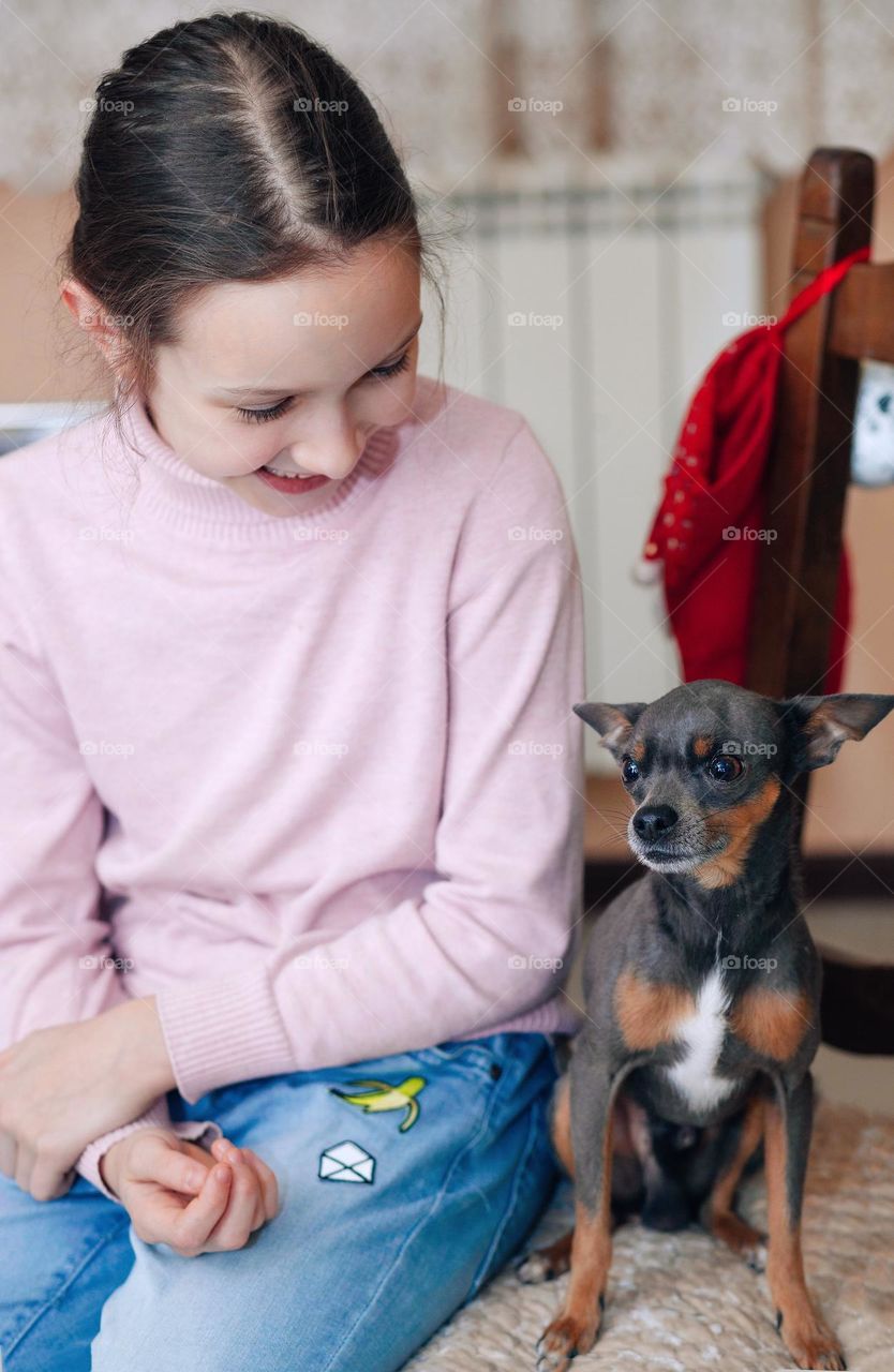 Girl and dog, toy terrier, friends, tenderness.

￼

￼