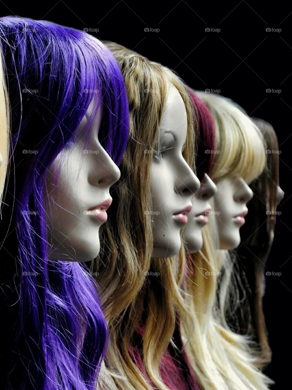 Mannequins displaying different coloured wigs.