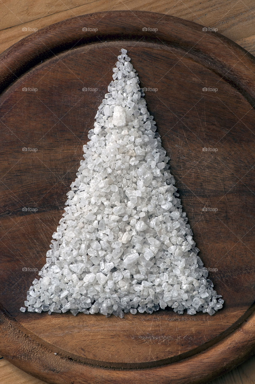 Christmas tree made of coarse salt on wooden cutting board