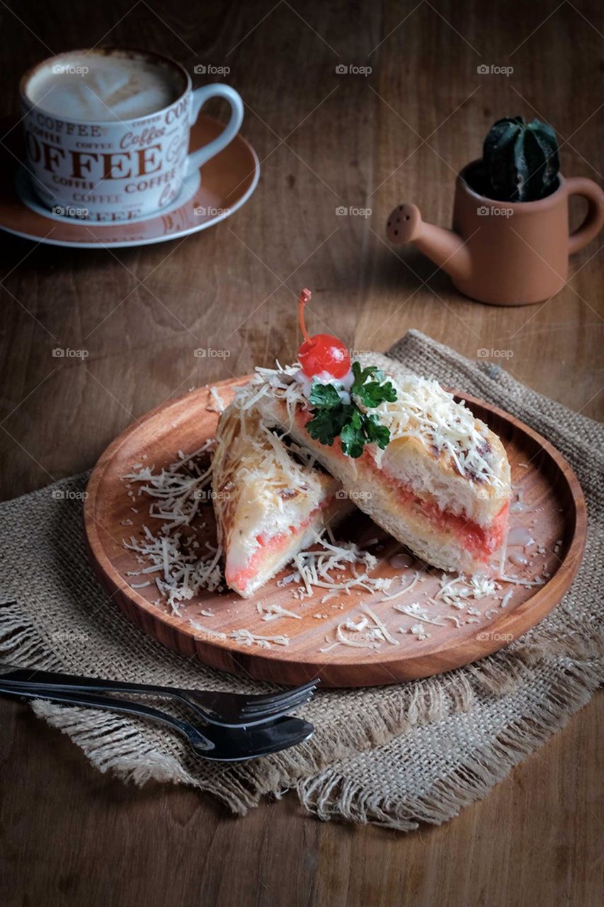 Toasted bread with cherry on top is served on a wooden table,perfect for Ramadan iftar