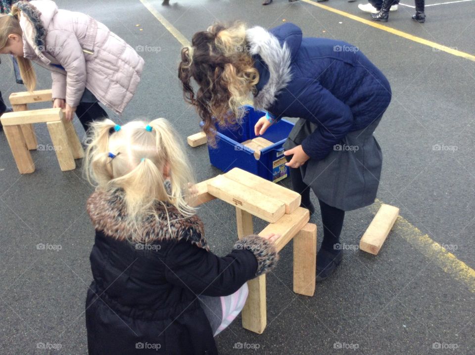 Little children are playing happily and make wooden tables 