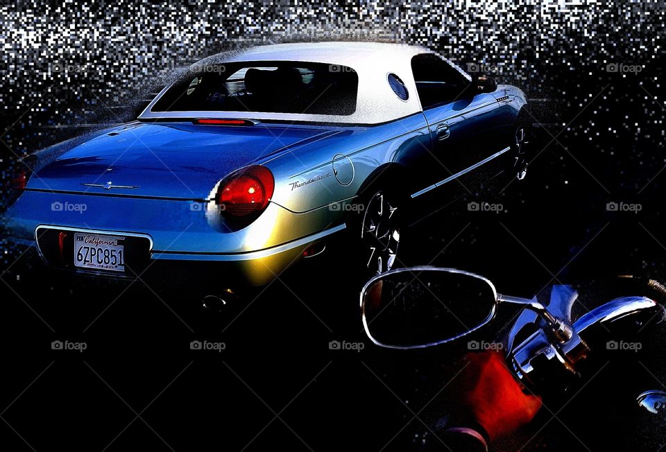 fancy car next to motorcycle. waiting at a stop light riding passenger on
 motorcycle