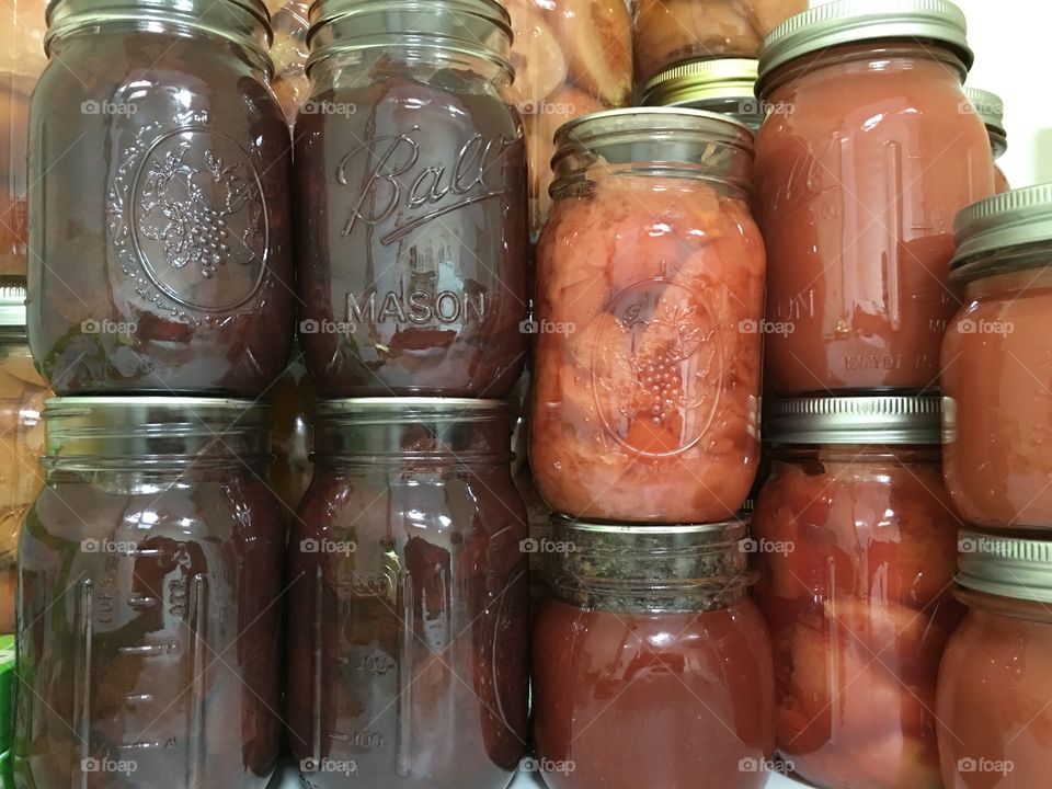 Homemade preserves jams and sauces in mason jars In cupboard pantry 
