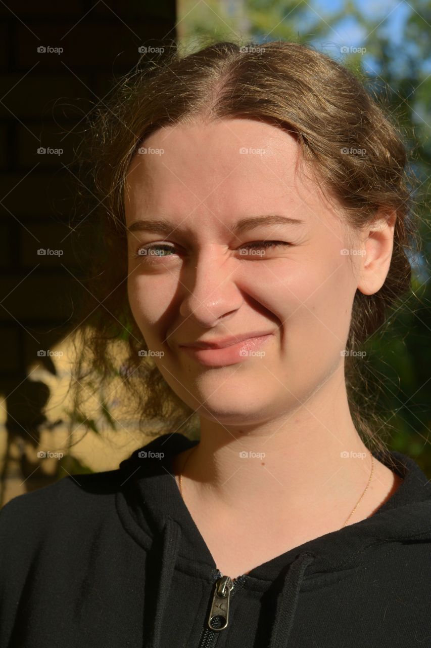 brunette girl beautiful portrait close up in sunlight outdoor brick wall background