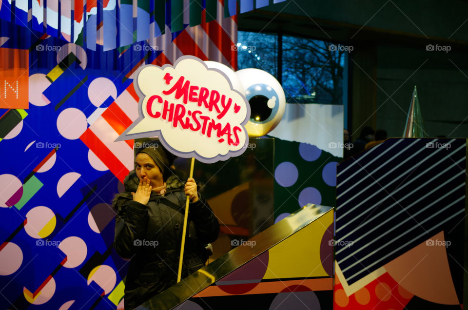 Portrait of a woman holding Christmas board