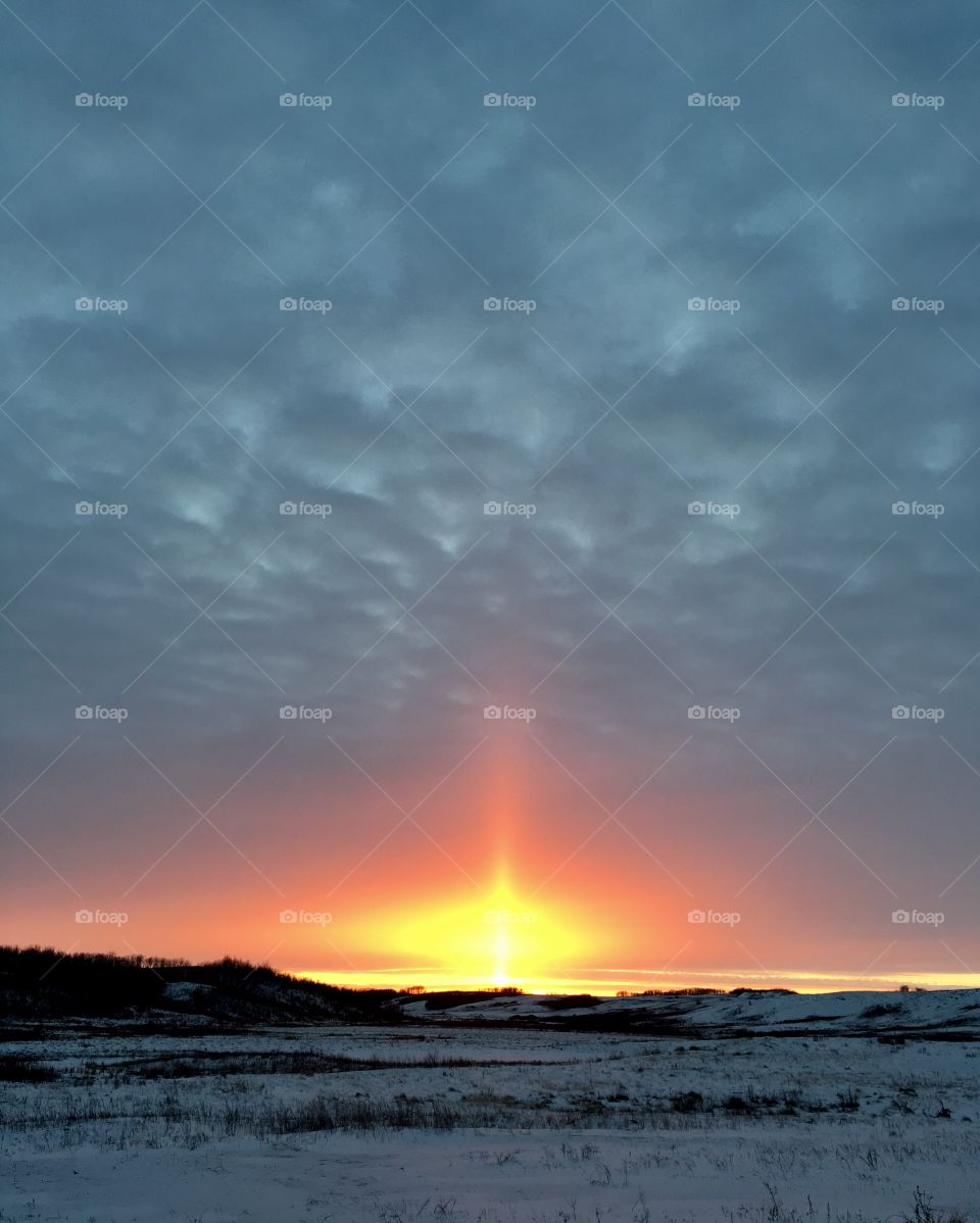 Snowy landscape against cloudy sky