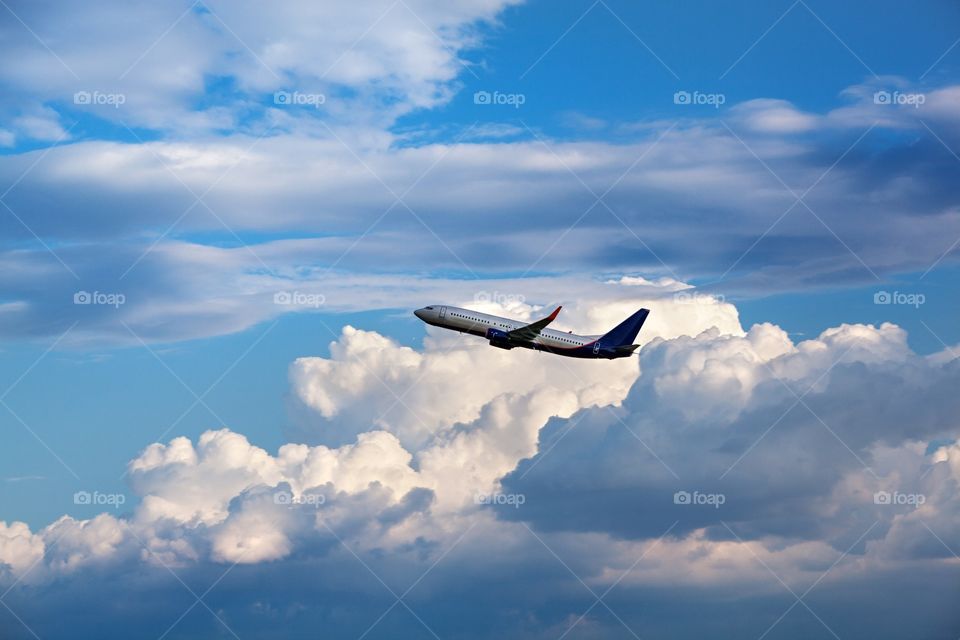 Plane. the plane took off into the sky with clouds