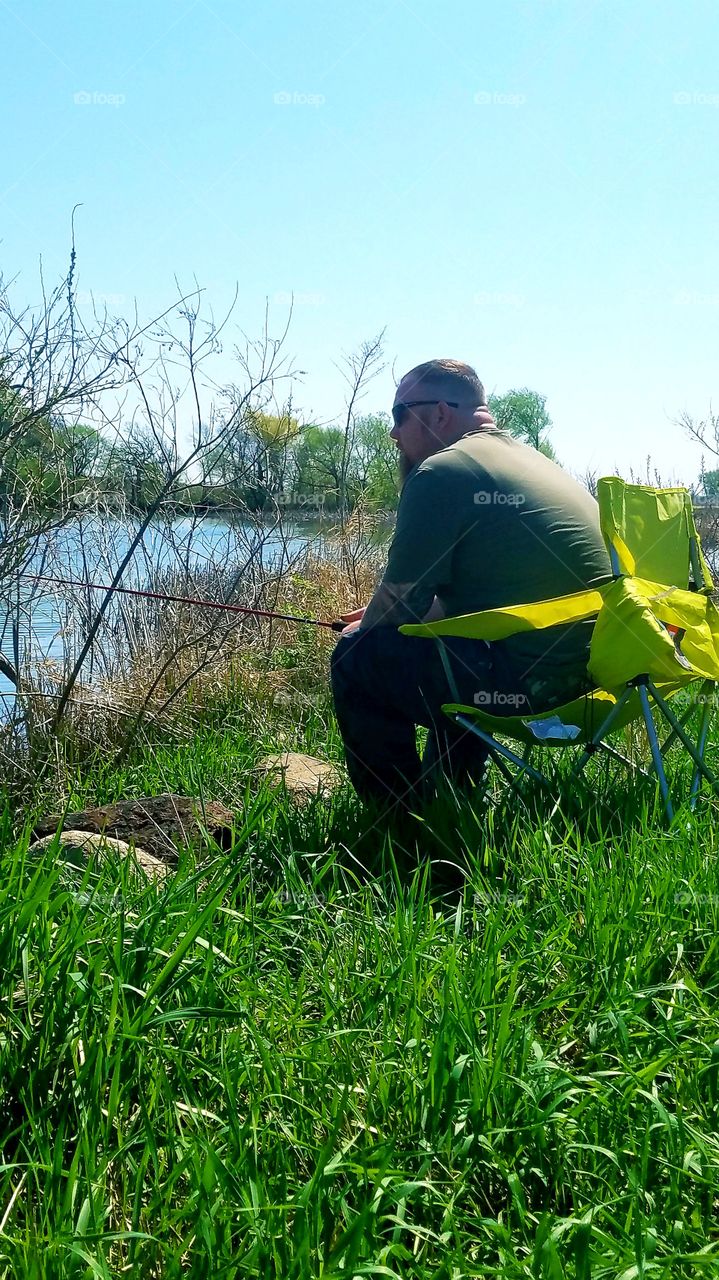 relaxed man enjoying fishing in June