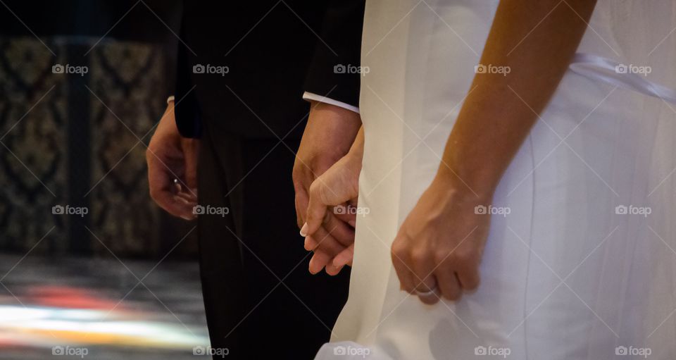 The bride and the groom joining hands during the wedding 