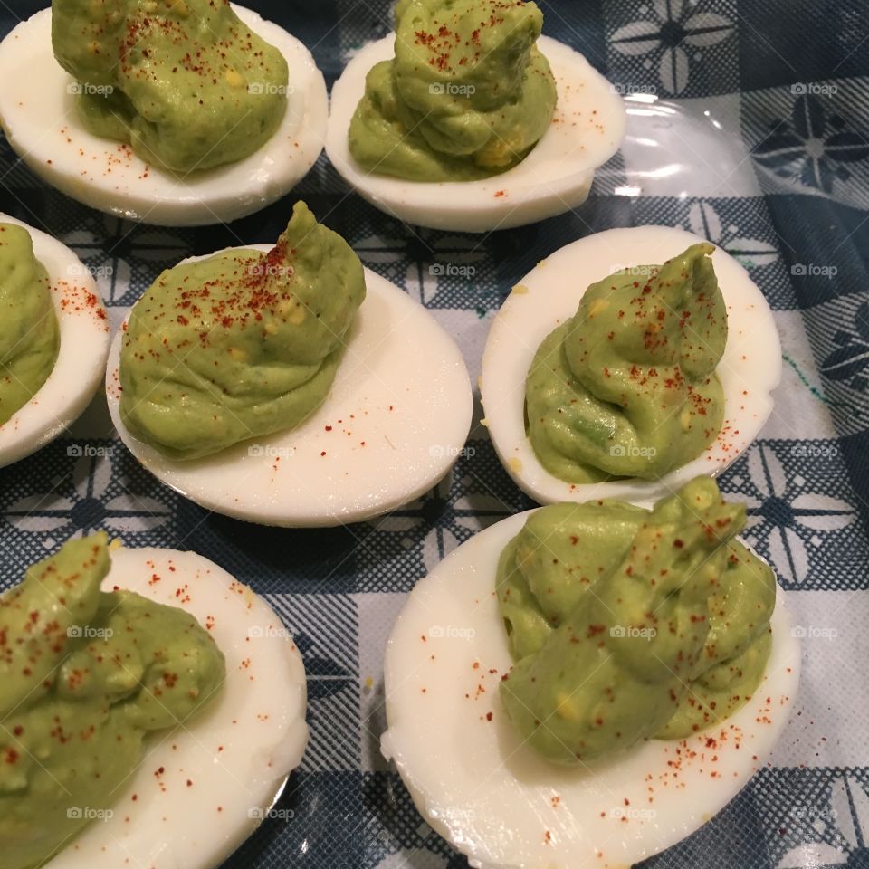 Avocado deviled eggs, with paprika sprinkled on top. 