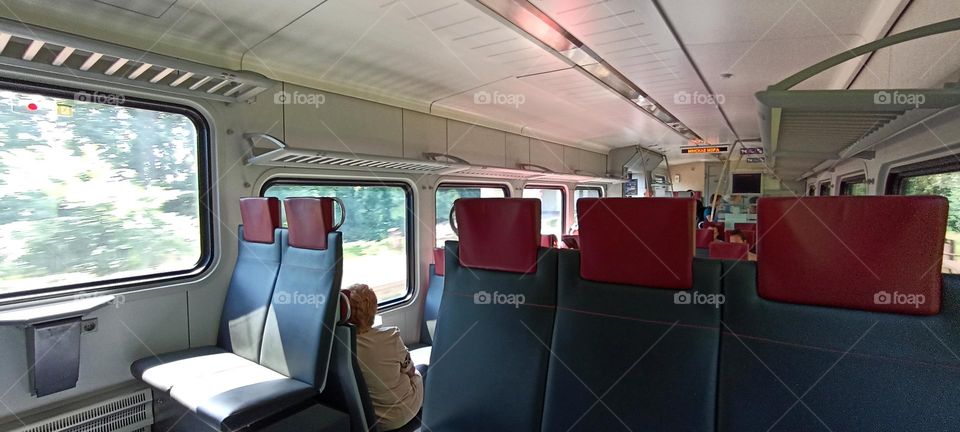 transportation on a electric train, view in the train people rides in the carriage on the railroad