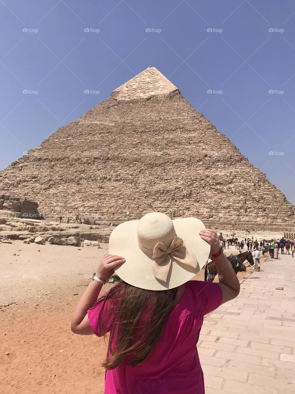 A girl posing in front of the pyramid.