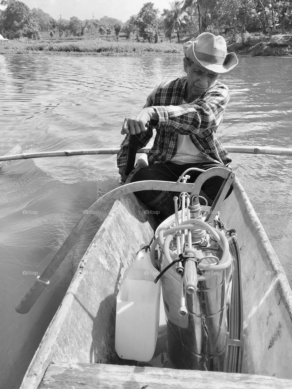 A farmer taking this humble boat going to his farmfield, loading with a farm sprayer.