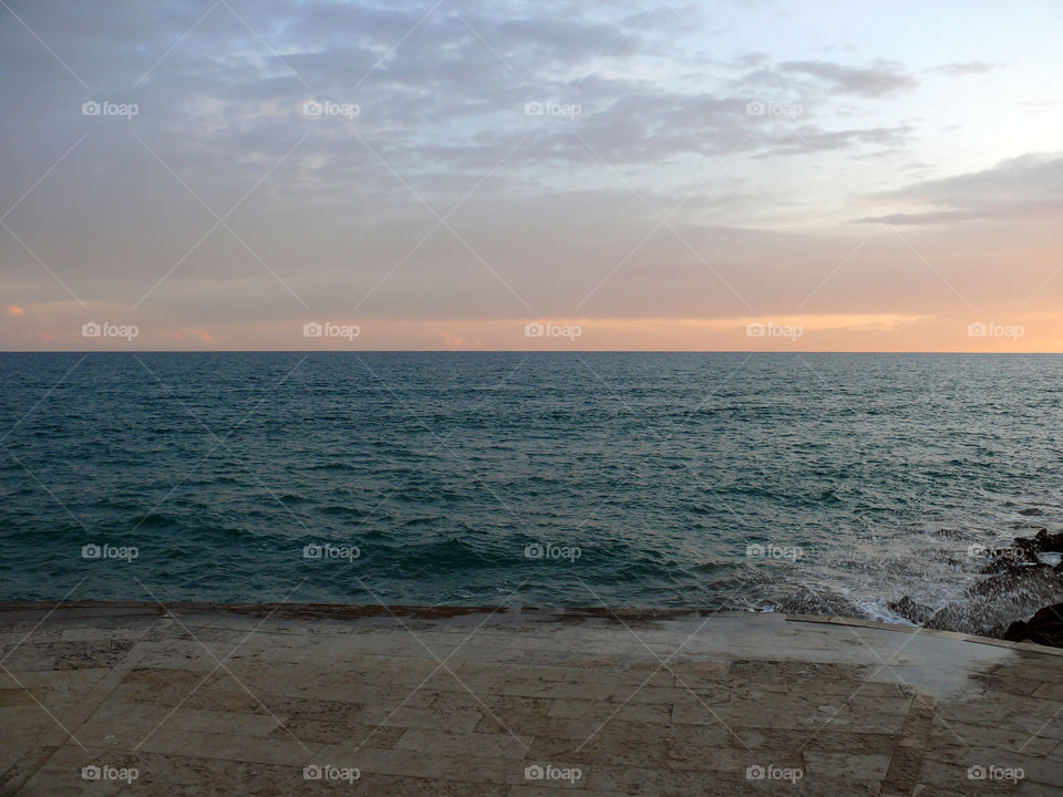 Sea scenics with horizon over water during sunset in Sitges, Spain.