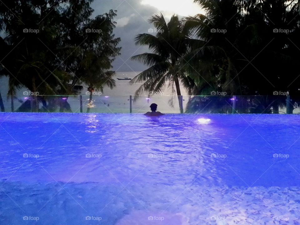 Silhouette of tree in infinity pool