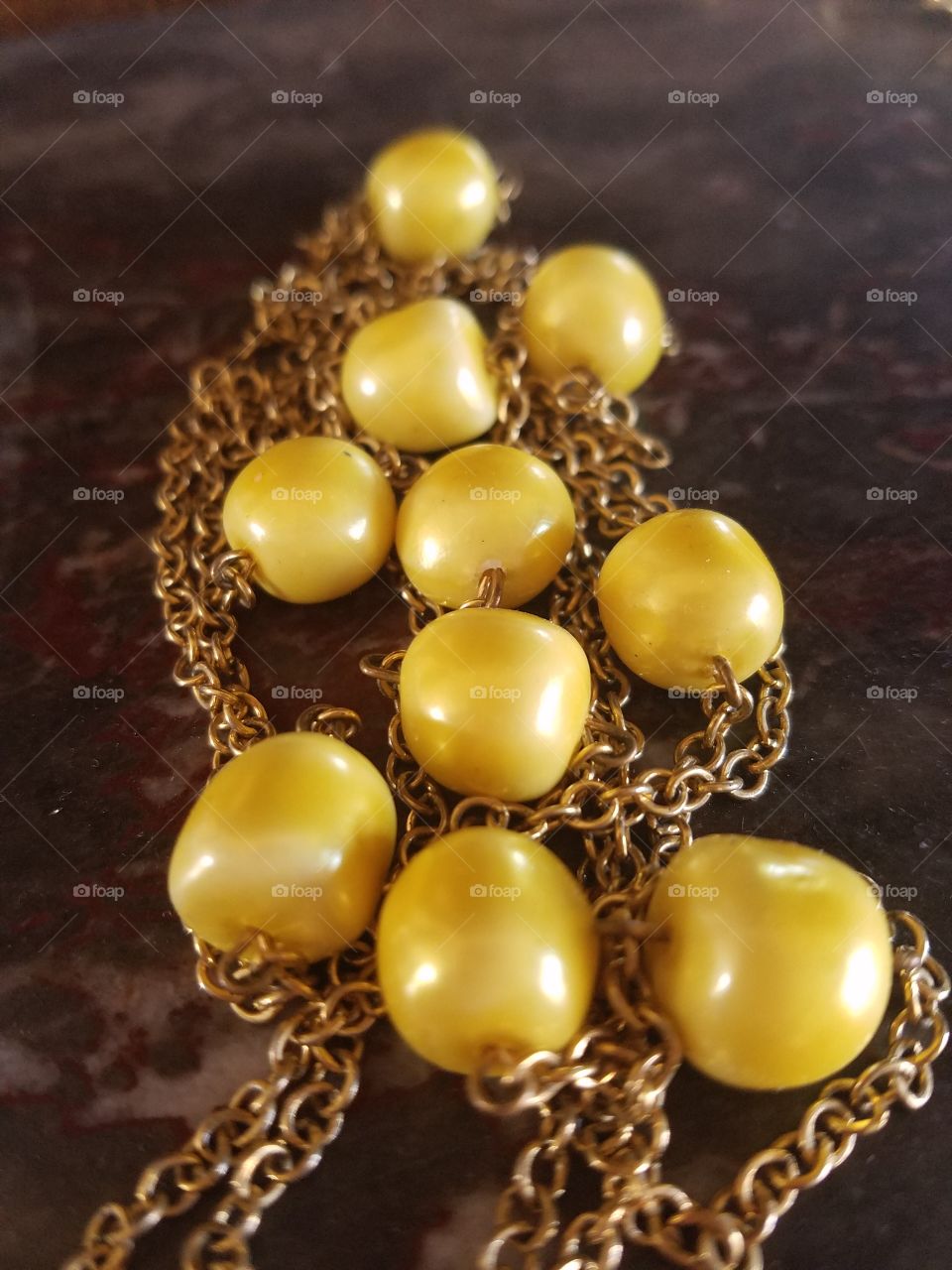 a necklace of glistening yellow beads surrounded by a simple gold chain capture the essence of the color yellow