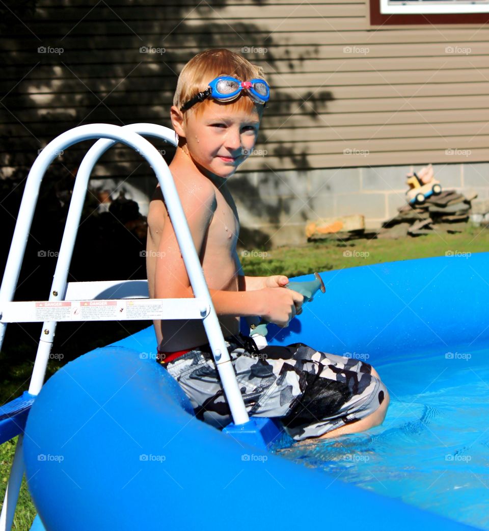 Young boy in garden swimming pool at outdoors