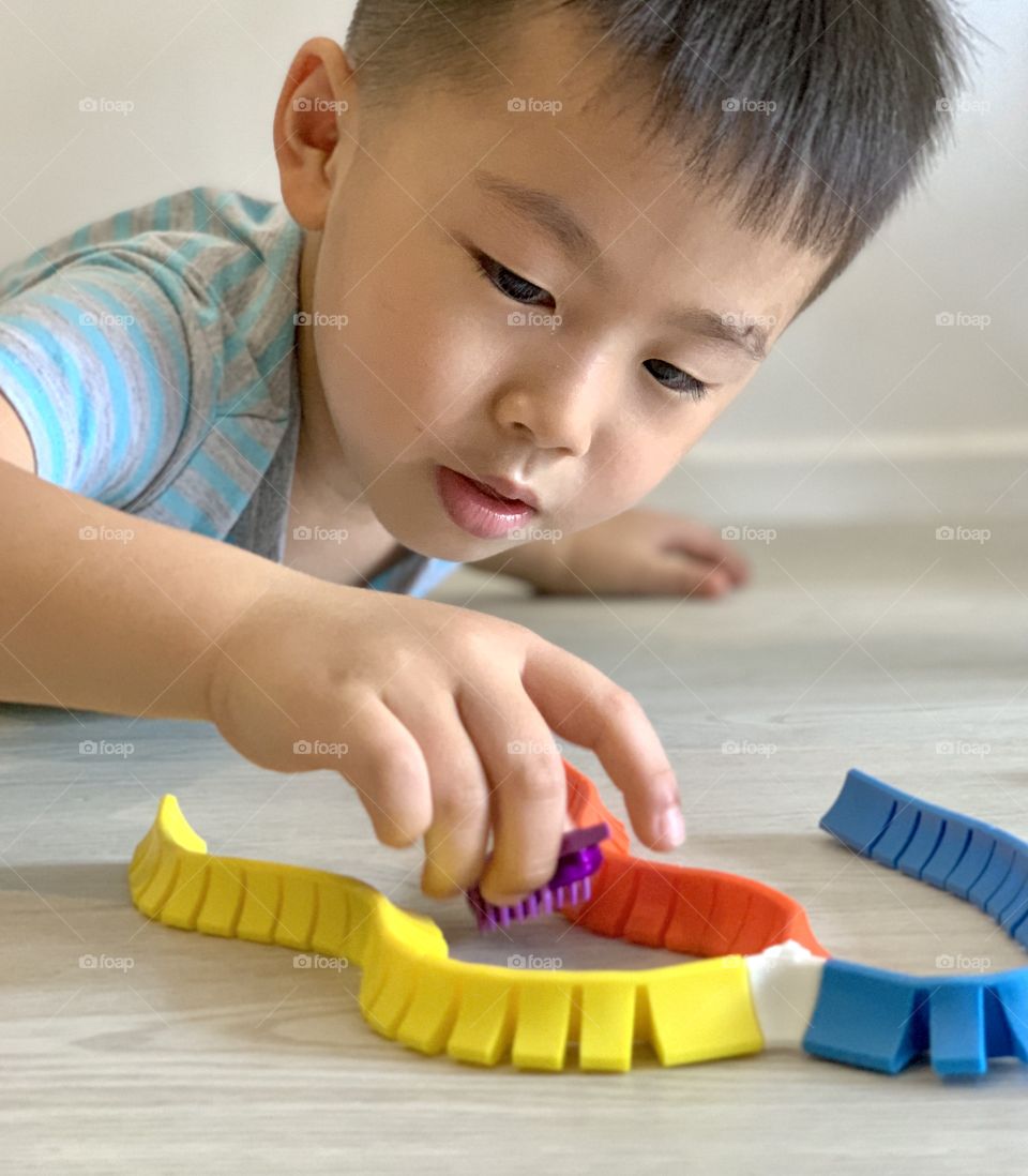 Asian boy playing with colourful toys 