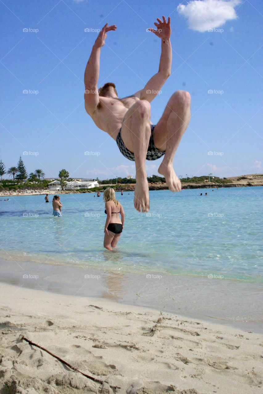 Man doing somersault at the beach