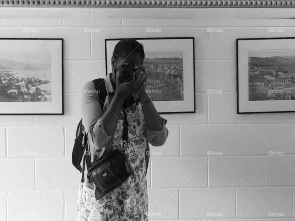 A retro monochrome picture of an adult in the mirror taking a selfie.