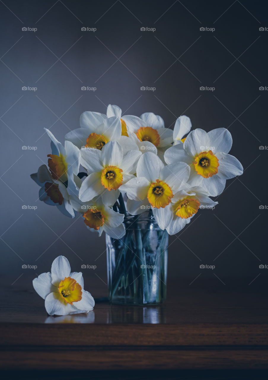 Bouquet of daffodil flowers in glass vase.