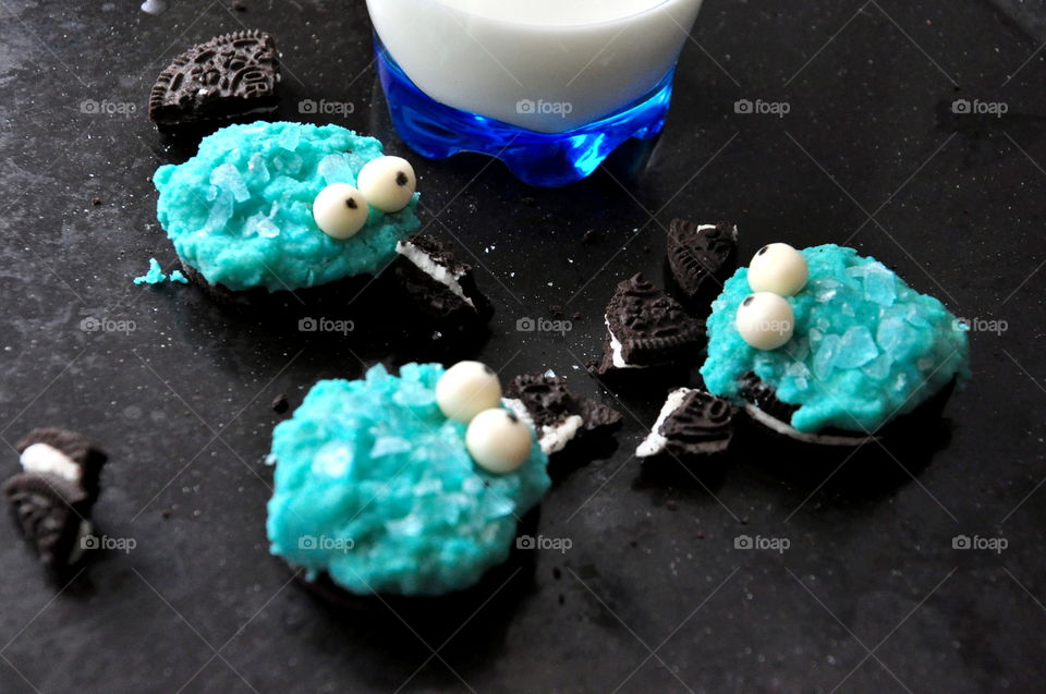 three oreo cookie monster dessert blue with glass of milk on black surface