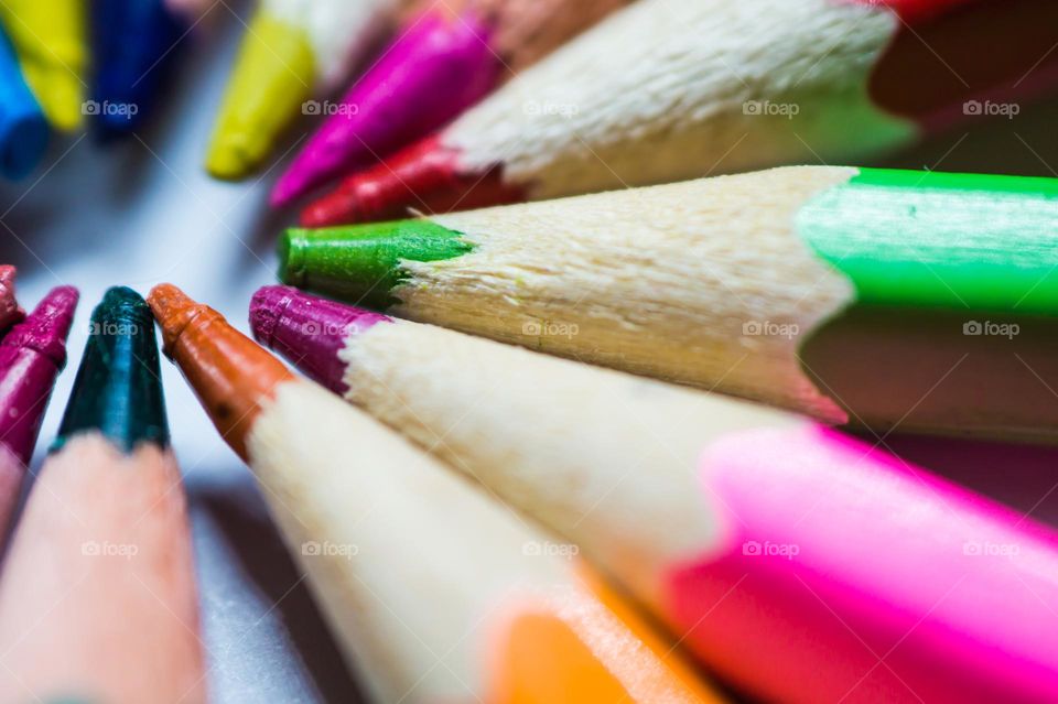 Multi-colored pencils lie together in a circle close-up.