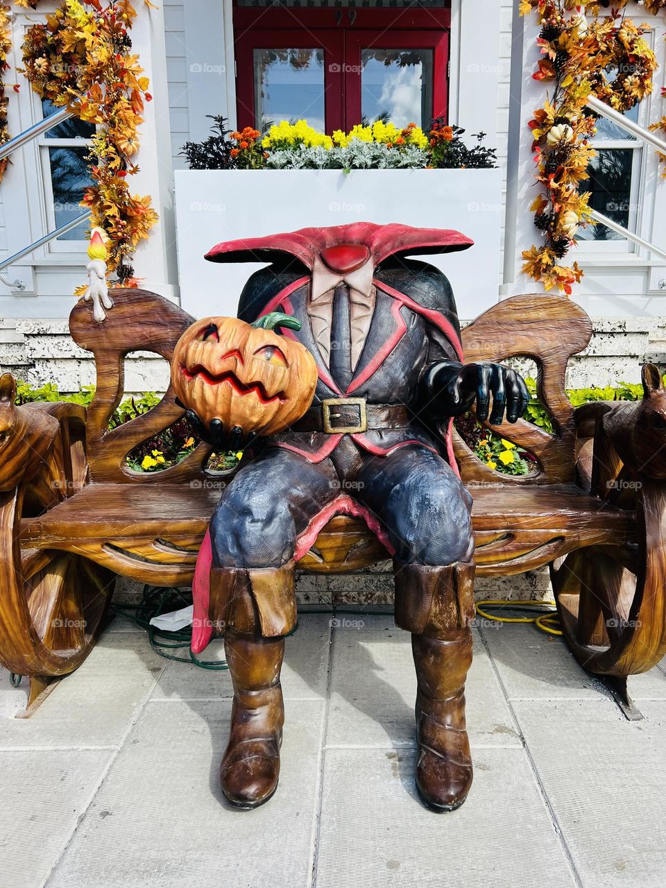 Halloween display of the Headless Horseman sitting on a bench outside a town post office