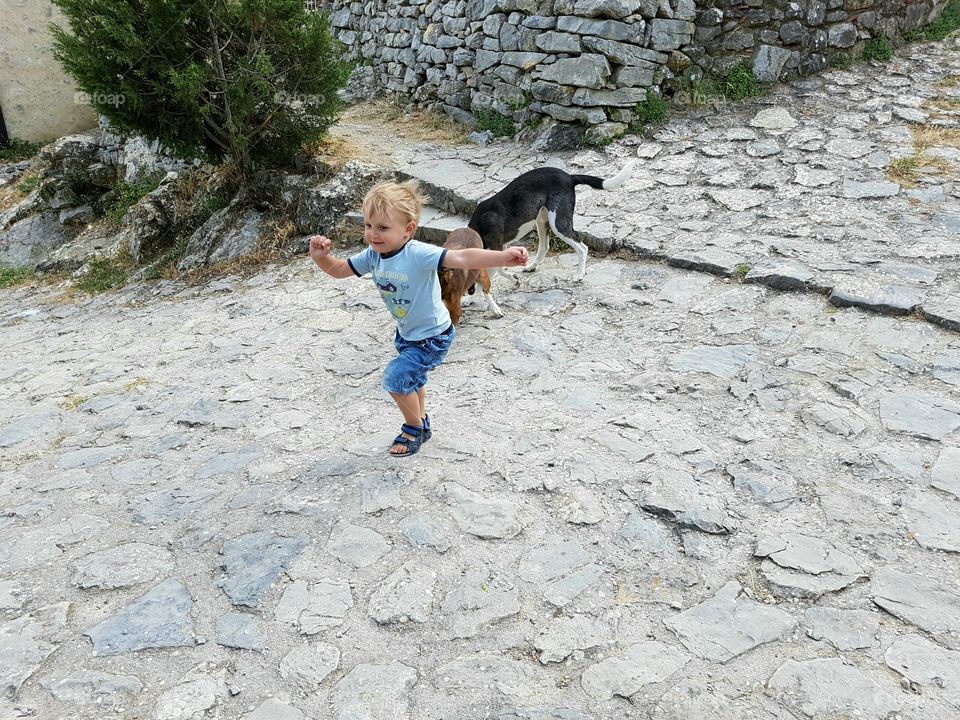 Little boy running from dog