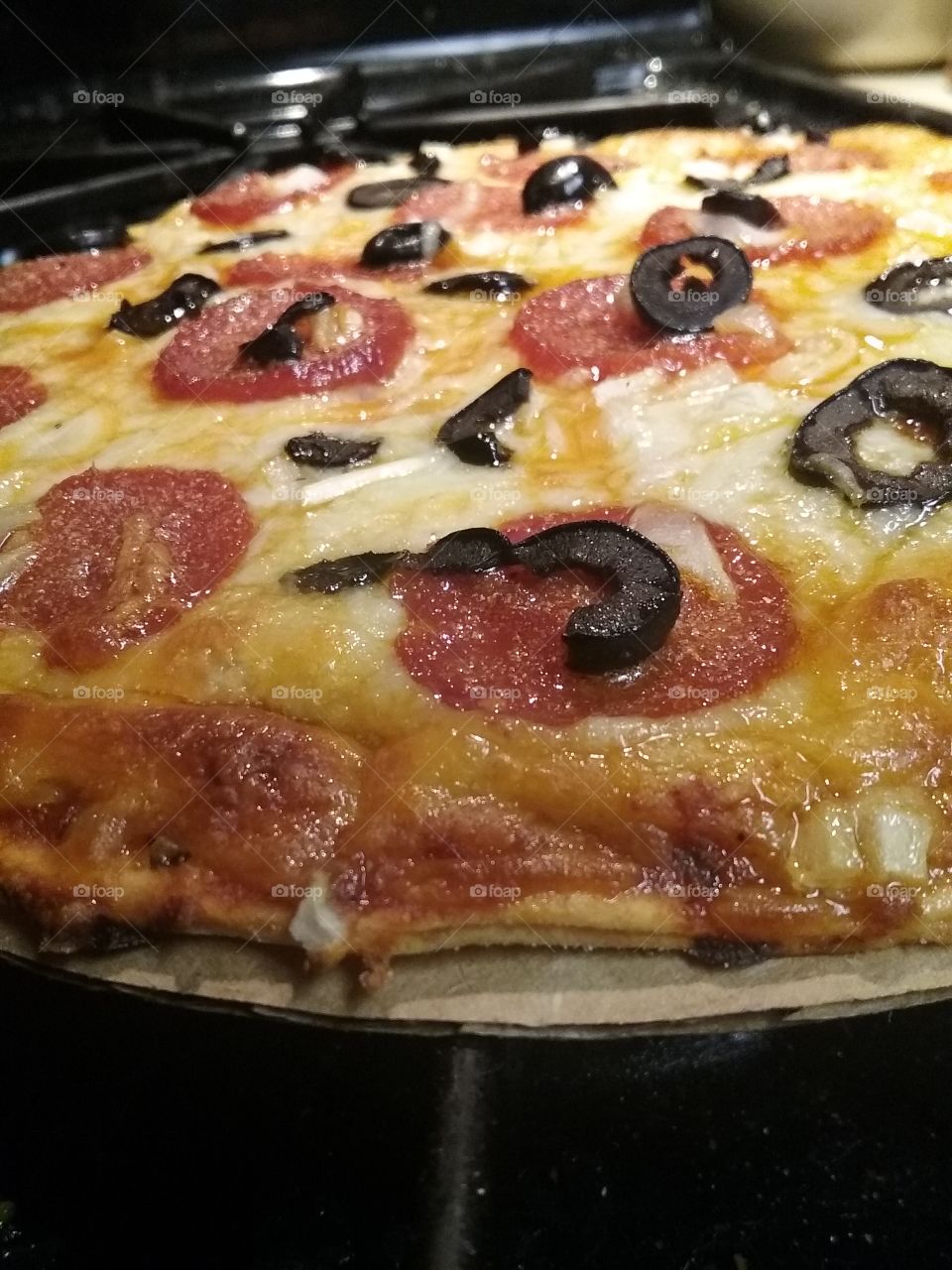 homemade gluten free pepperoni, onion, and black Olive pizza