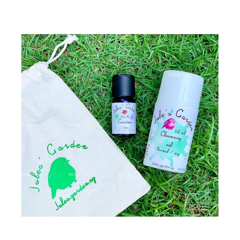 Natural products such as Garden Essential oil in a garden setting with leaves and facial cleansing oil