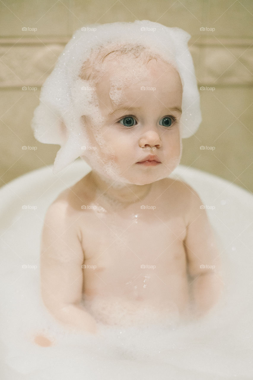 Cute baby-girl with foam on head