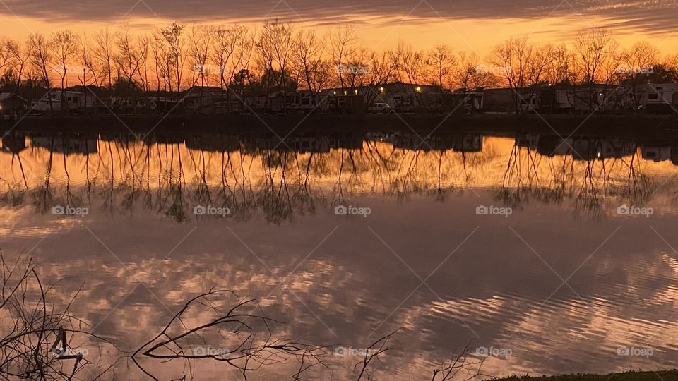 This is a Reflection from Top to Bottom or Top Of Lake Waters. Sunset colors are inviting more from the sunset. Bubbly High thick clouds rest on top of Lake Waters