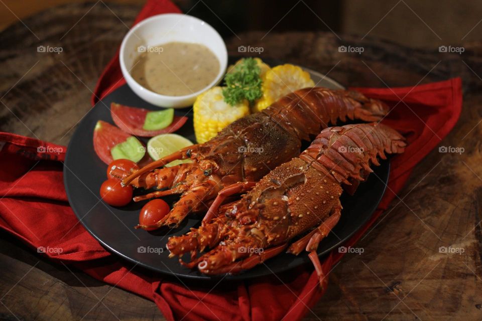 Lobster creamy garlic Lobster served with corn, tomatoes, lemon wedges, cherry and Asian-style creamy garlic sauce.