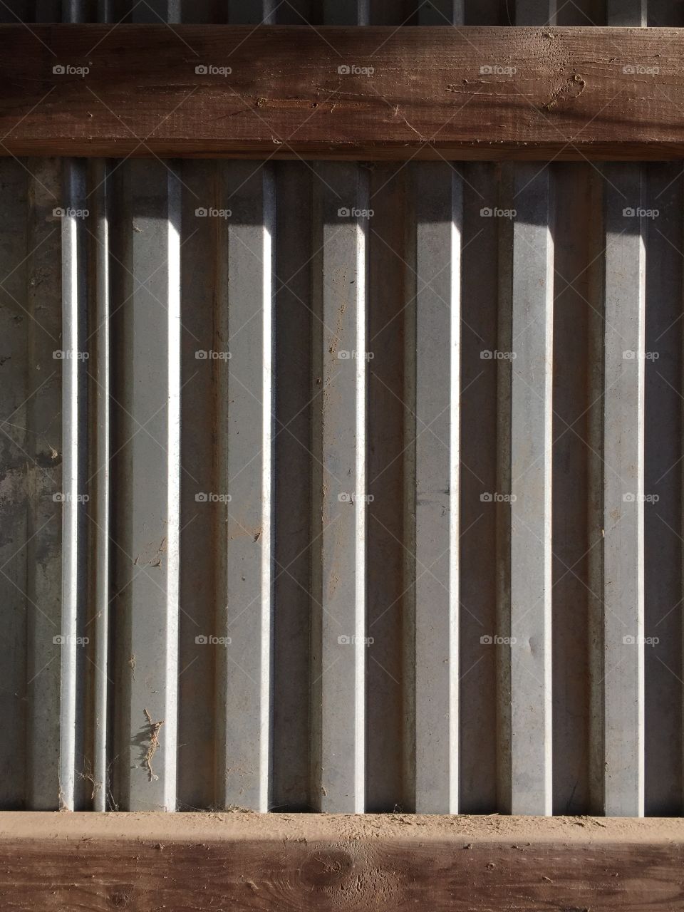 Sunlight and shadows of metal siding and wooden interior structure 