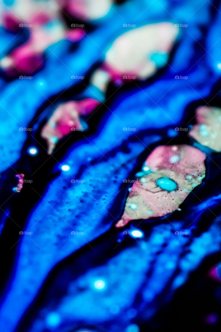 The ink to refill the printer cartridge was spilled onto the white washbasin and the paints blended into abstract drips and patterns.