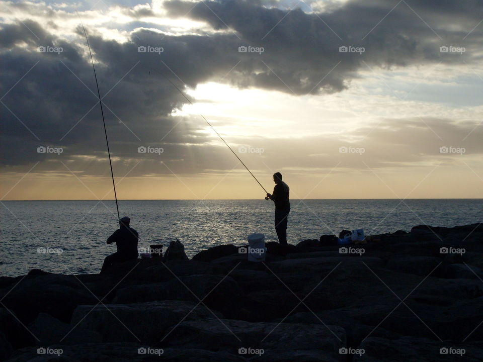 Fishermen whit fishing rod at evening.