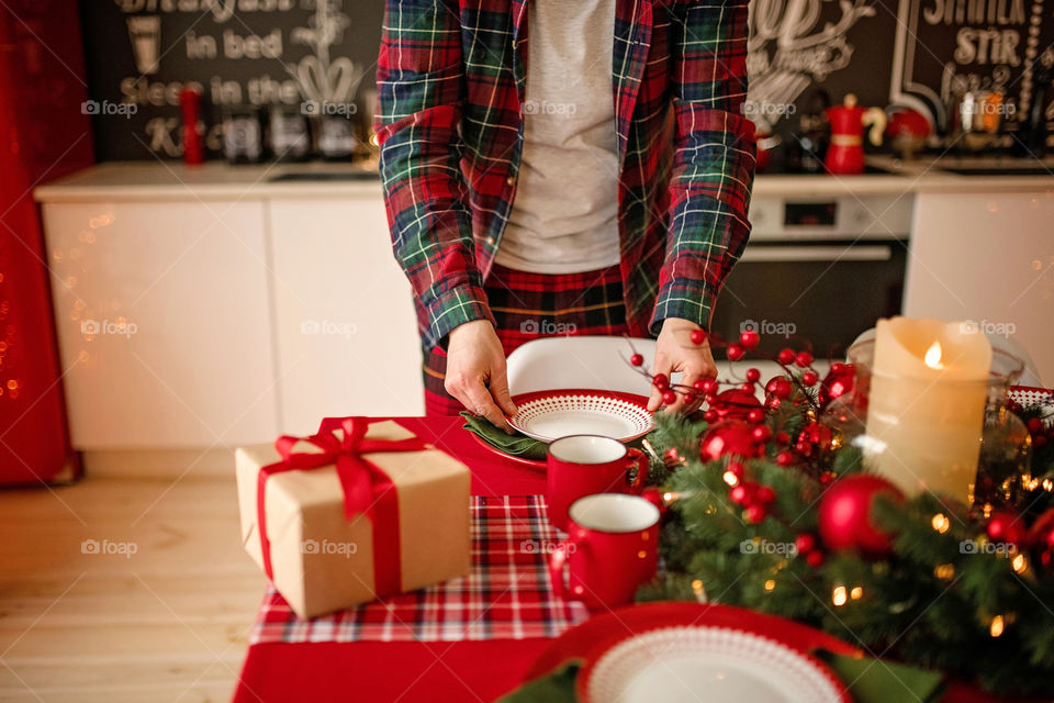 man sets a beautiful decorated winter table for a festive dinner.  Merry Christmas and Happy New Year.