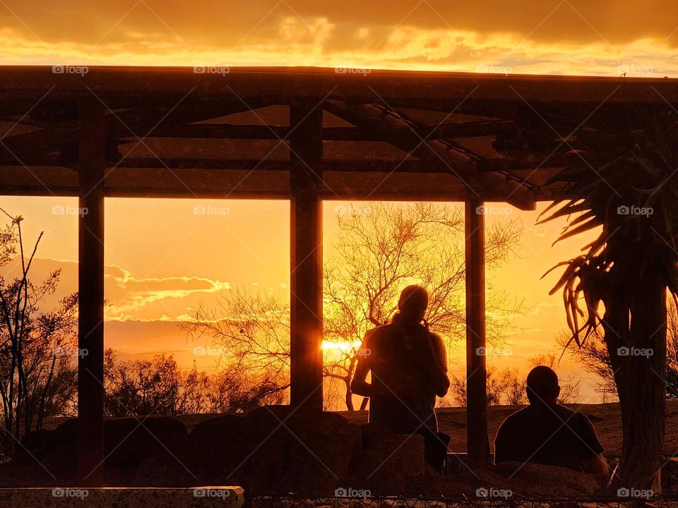 People gather underneath a veranda to view a spectacular Arizona sunset as the scene erupts into a warm hue