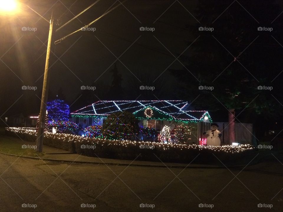 Christmas lights and decorations on a house seen at night.