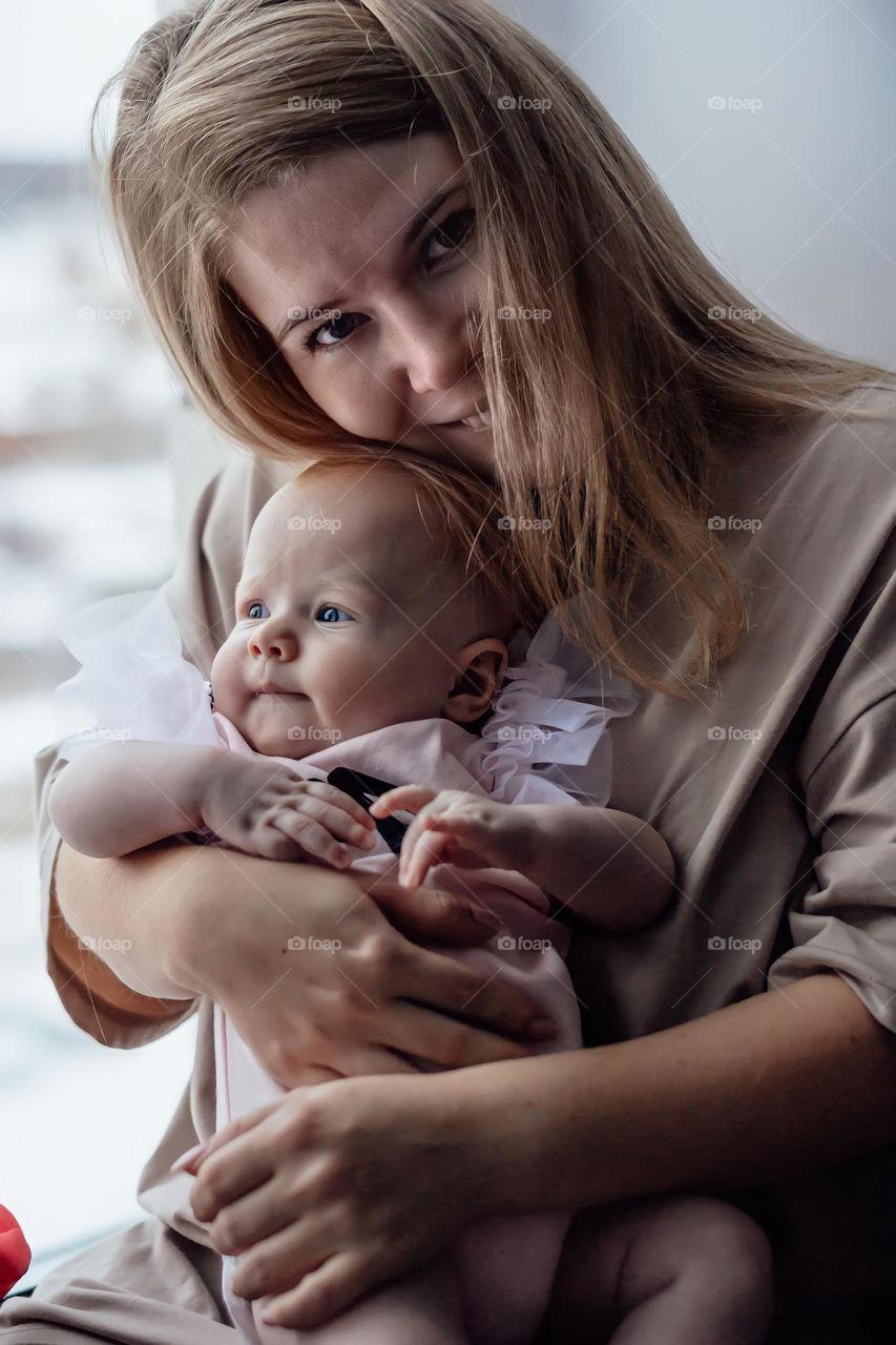 Mom and baby sitting near window 