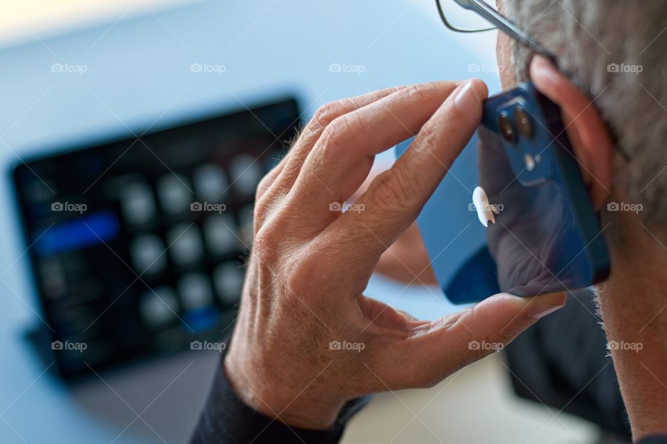 Man talking on his iPhone and working with his iPad