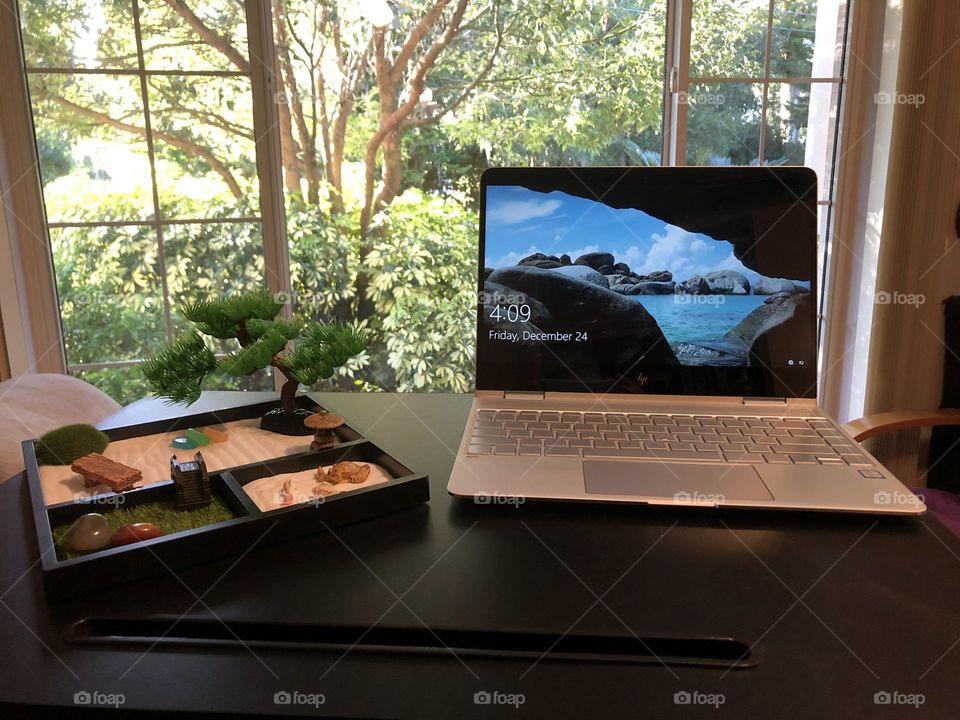 Desk with laptop, a relaxing view, and a zen garden to improve creativity and performance